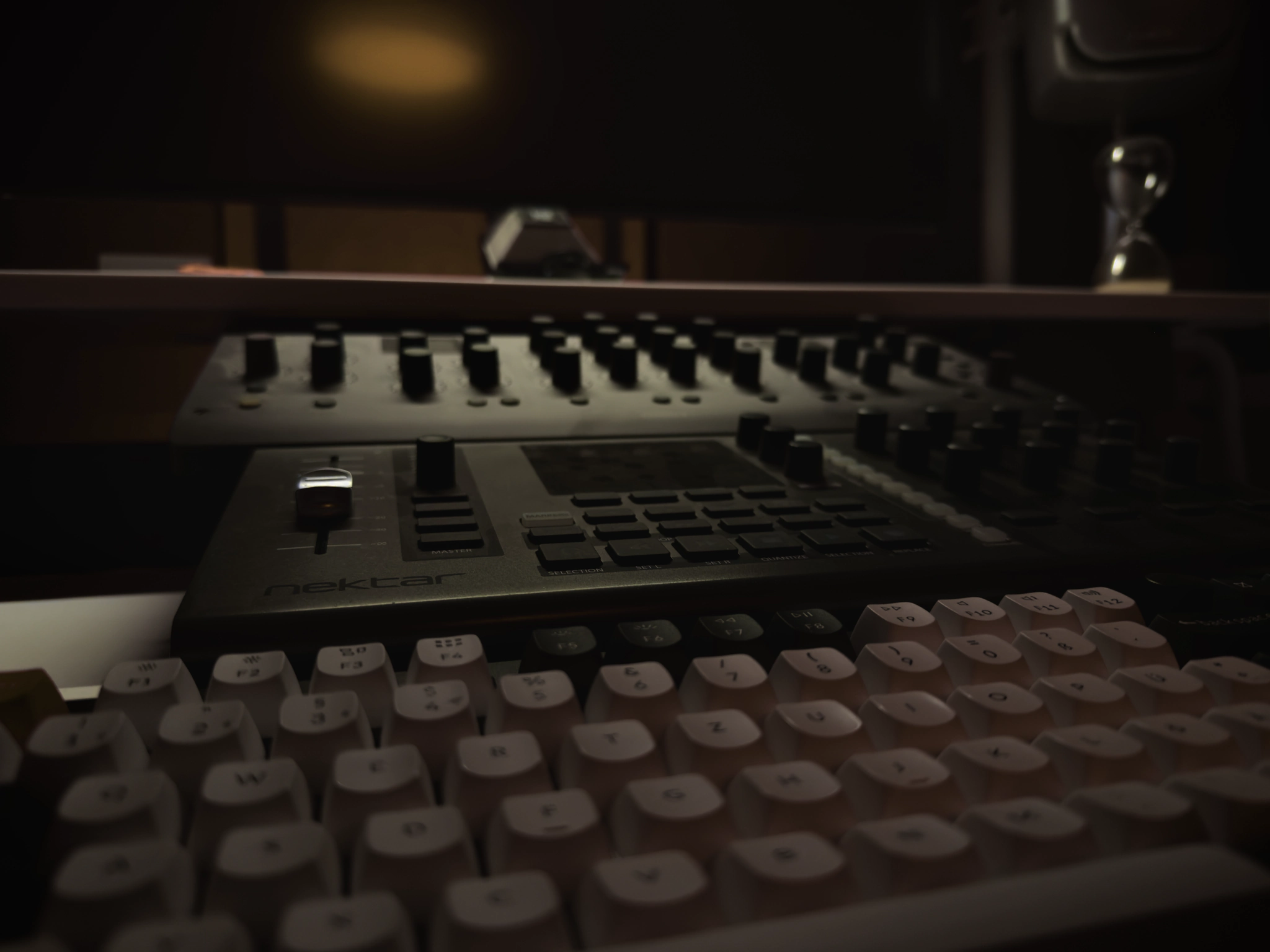 Close view of the controller and keyboard on the studio desk at night