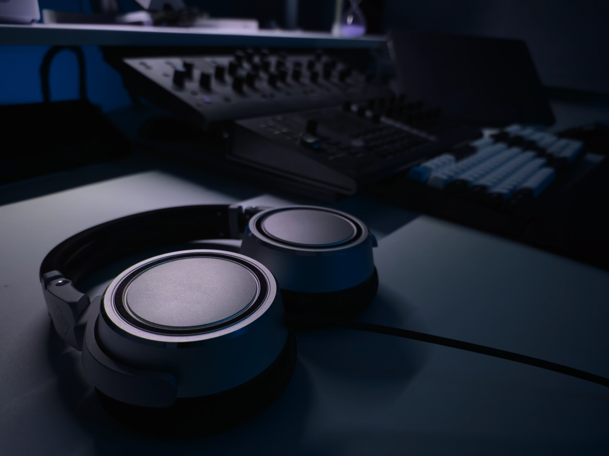 Neumann NDH 20 headphones resting on the studio desk beside the controllers